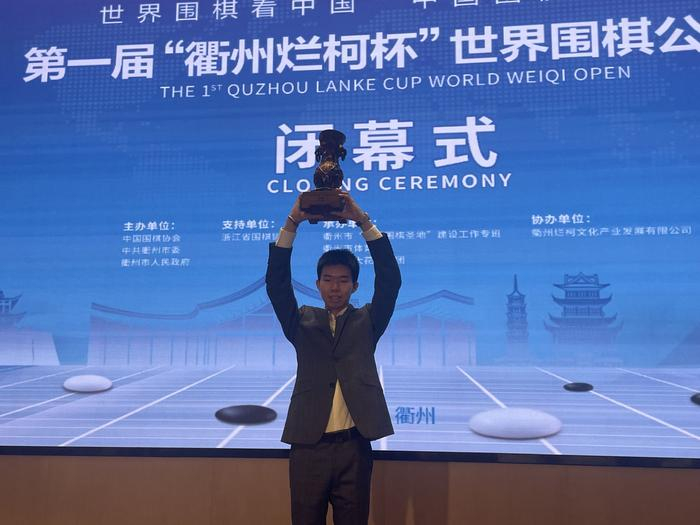 辜梓豪高举烂柯杯冠军奖杯。