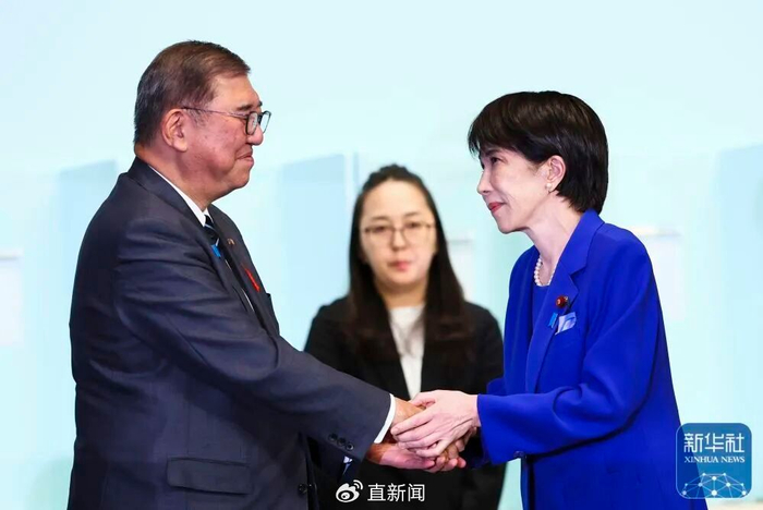 10月4日，在日本东京的自民党总部，高市早苗（右）在自民党总裁选举中胜出后向日本首相、自民党前任总裁石破茂（左）致意。