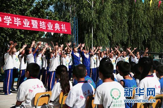 图为蒲公英中学在校园操场上举行初三毕业生毕业暨结业典礼 闫梦 摄