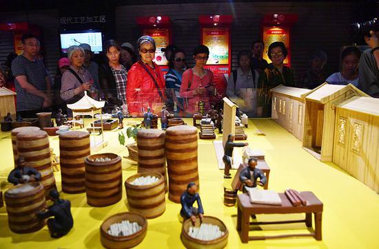 市民观看传统腐乳制作工艺流程展示沙盘。