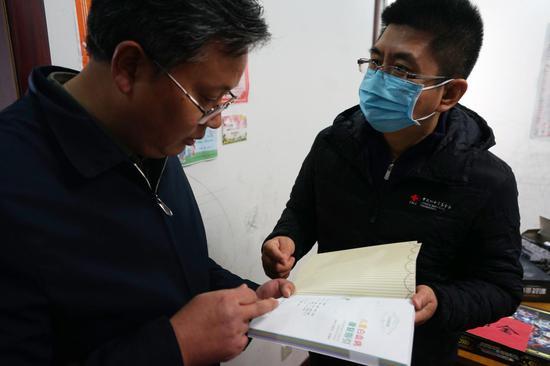 中国红基会的工作人员向小峰的爸爸赠送了《儿童白血病康复指引》
