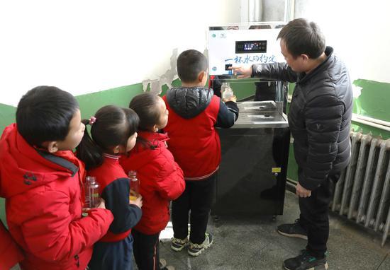 阁楼小学周校长与孩子们体验由“绿动未来”平台捐赠的净水设备