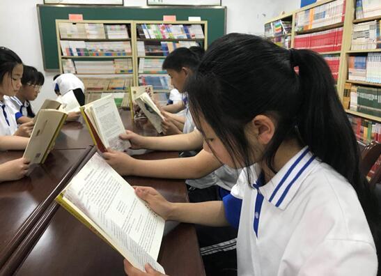 丹凤县棣花初级中学的同学们阅读课外书籍。