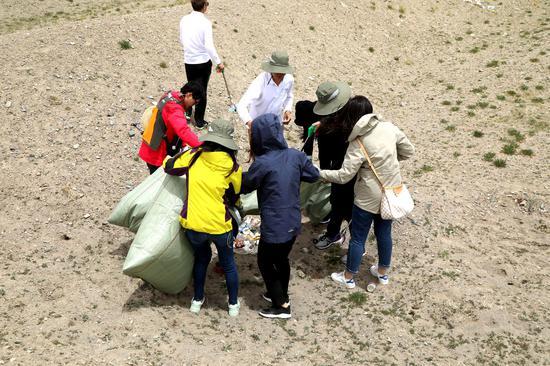 志愿者们化身“清道夫”,在青藏线清洁行动中捡拾垃圾