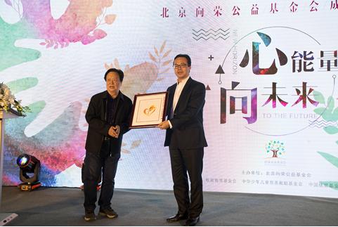 向荣公益基金会创始人刘圣先生接受湘西州关工委副主任龙永芳赠送苗绣作品《感恩》