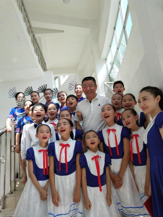 第五届童声飞扬音乐会上成美理事长蒋先生在后台了解孩子们的音乐学习情况