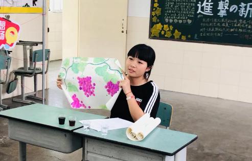 在成都面试现场,一位申请者向面试官展示自己的水彩画