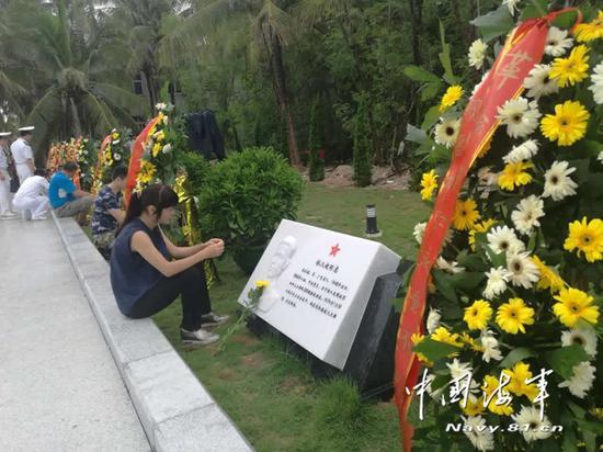 西沙海战烈士遗属坐在亲人石砌铭牌前无语哽咽。