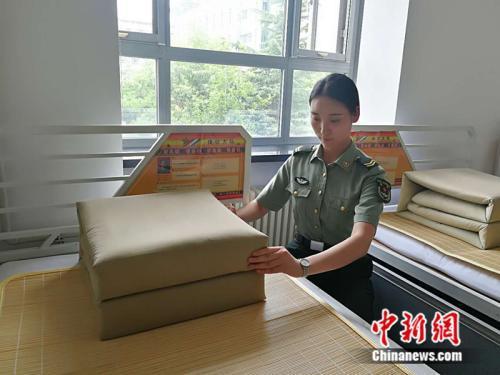 毛雯在整理自己的被褥 中新网记者 张尼 摄