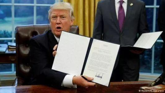 图为特朗普签署行政命令,宣布美国退出TPP。