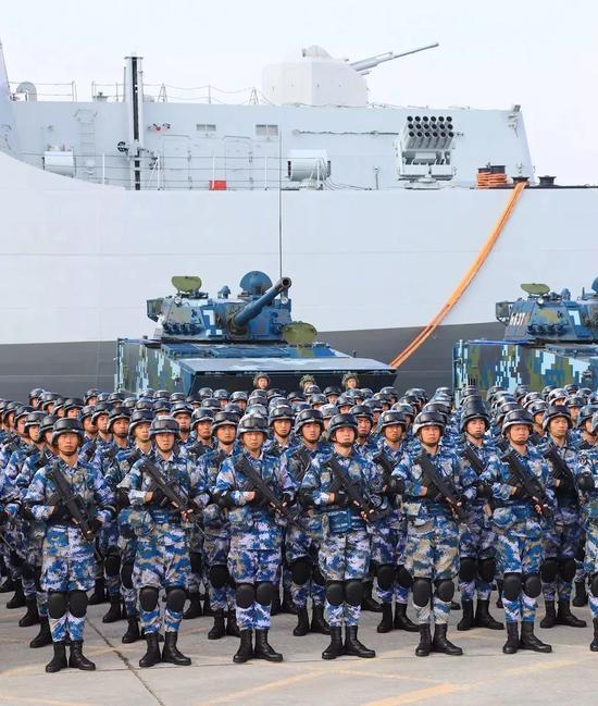 中国海军陆战队士兵、两栖战车准备登上071型船坞登陆舰。