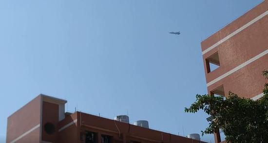 图为歼-20低空放下起落架飞临学校上空的瞬间。