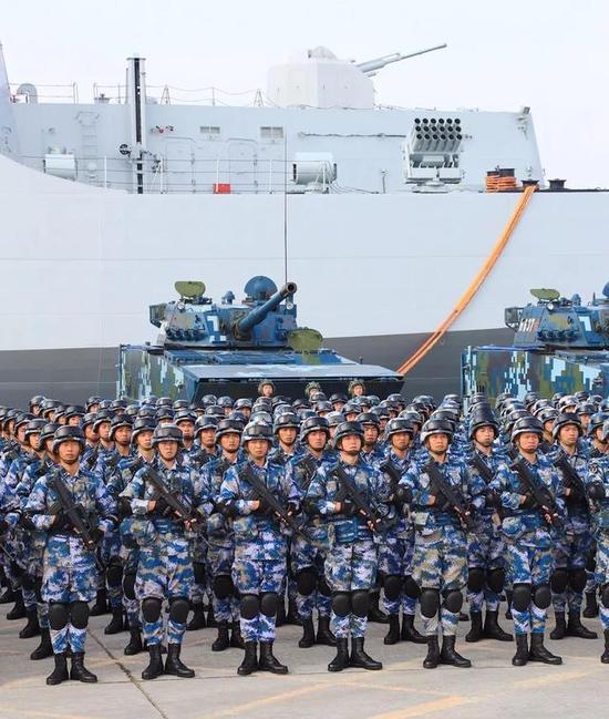 海军陆战队员和两栖战车准备登上后面的071型船坞登陆舰。