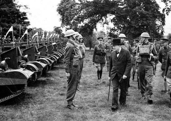 1940年7月,英国首相温斯顿·丘吉尔检阅英国近卫步兵第一团,士兵们在装备布伦式轻机枪的装甲车前立正。丘吉尔在一战时期也是坦克战的推动者,只可惜他当时是海军大臣