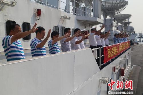 船员与送行人员挥手告别。