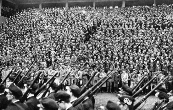 1943年,由于兵力不足,日本开始动员20岁以上的文科学生实行学徒出阵。图为10月21日,来自东京、神奈川等77所学校的准备出征沙场的学生与其余5万名一般在校生聚集在明治神宫外苑竞技场举办壮行会