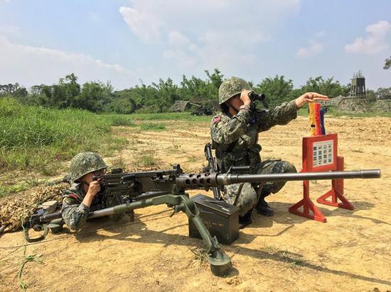 两名女性官兵操作50机枪的照片,遭网友炮轰姿势错误。(图片来源:台湾“东森新闻云”)