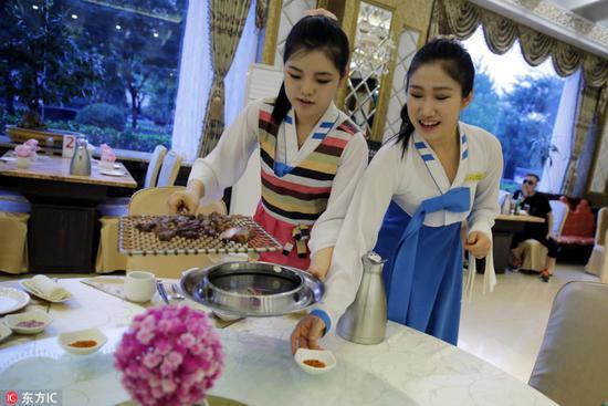 中国北京,一家朝鲜餐厅内,正在上菜的服务员。