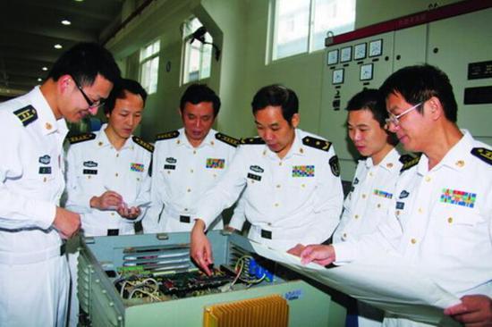 资料图:马伟明(右三)在指导课题组攻关