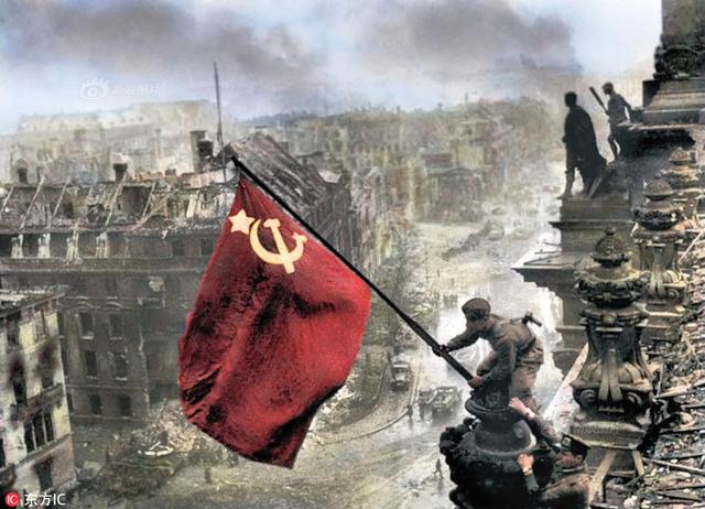 图为苏联士兵在国会大厦顶上举起苏联国旗.