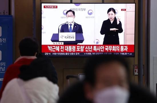 当地时间2021年12月24日,韩国首尔,韩国民众在车站收看前总统朴槿惠获特别赦免的新闻报道。图/IC photo