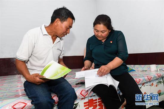 7月16日,赤峰市松山区大庙镇小庙子村党支部书记赵会杰(右)回到村庄后,询问贫困户沈占阳的情况。新华社记者 刘磊 摄