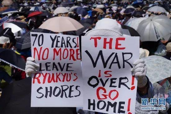 (图为民众手举标语要求美军离开冲绳,驻日美军同样风波不断,美国不得不考虑其影响)
