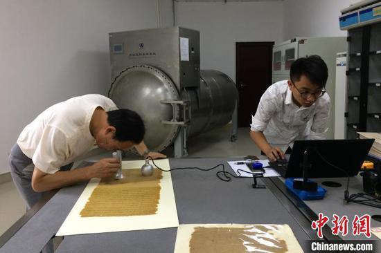 技术人员对“圣旨”原件进行分析采样 (资料图 钟欣 摄)