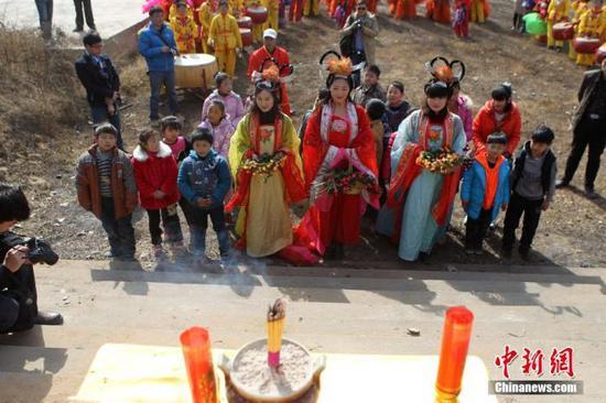 资料图:民众在“春姑娘”的带领下祭拜灶神,当日是农历腊月二十三,中国传统“小年”(中新社发 王中举 摄)