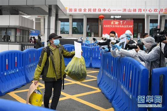 图 | 2 月 11 日,一名出院患者展示出院证明。当日,武汉市武昌方舱医院首批新冠肺炎轻症患者经过治疗出院。(来源:新华社)
