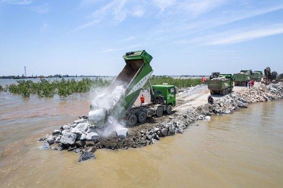7月7日,在湖南省岳阳市华容县团洲垸洞庭湖大堤决口现场,抢险队伍在进行堵口作业(无人机照片)。新华社记者陈思汗 摄
