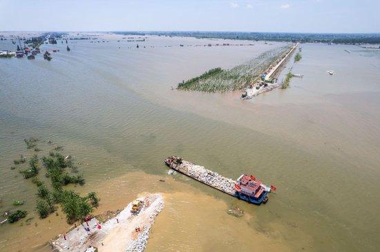 7月7日,在湖南省岳阳市华容县团洲垸洞庭湖大堤决口现场,抢险队伍在进行堵口作业(无人机照片)。新华社记者 陈思汗 摄