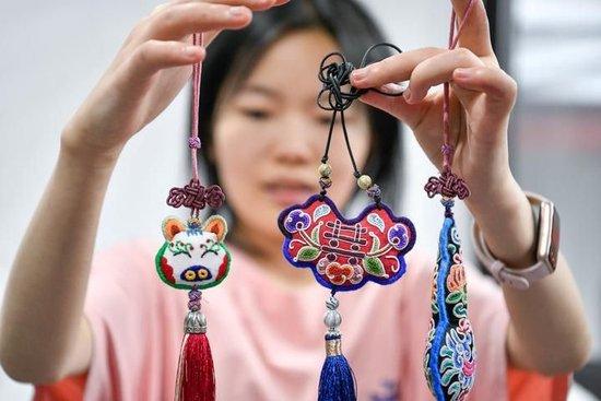  多彩贵州文化产业投资集团的工作人员在展示苗绣文创产品（5月23日摄）。新华社记者 杨文斌 摄