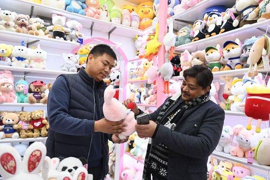 来自印度的客商(右)在义乌国际商贸城的一家玩具店铺内选购。