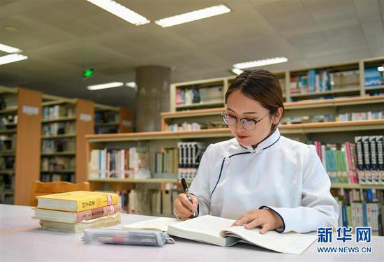 7月16日,内蒙古大学学生包高娃在图书馆学习。新华社记者 彭源 摄