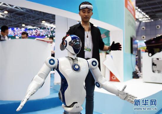 在全国大众创业万众创新活动周北京会场主题展上,一名工作人员在展示一款仿生机器人(2017年9月15日摄)。新华社记者 张晨霖 摄