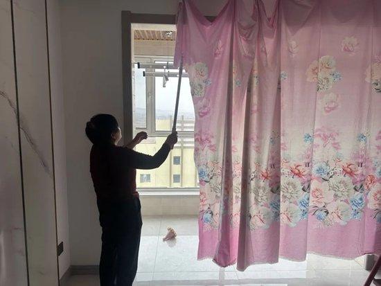 涉案房屋内被点燃的窗帘,烧损处已被男方母亲裁下丢弃