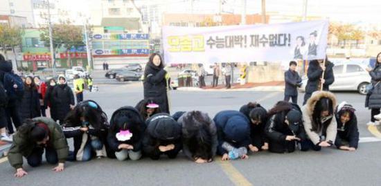 (韩国一处高中前,后辈为高三前辈行大礼 来源:《中部每日》)