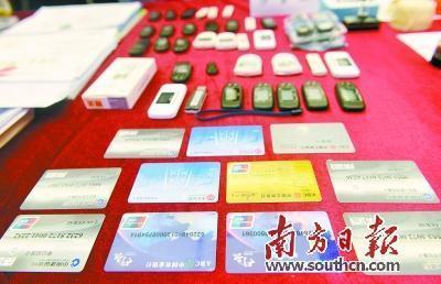 广东警方展示缴获的电信诈骗涉案银行卡、电子密码器等