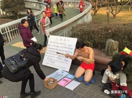 2017年1月,北京地铁复兴门站出口附近,好心人在向“打股救子”的樊富贵捐款。