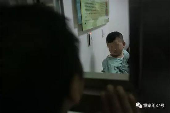2月21日晚,樊富贵与在病房里的儿子透过探视窗打招呼。