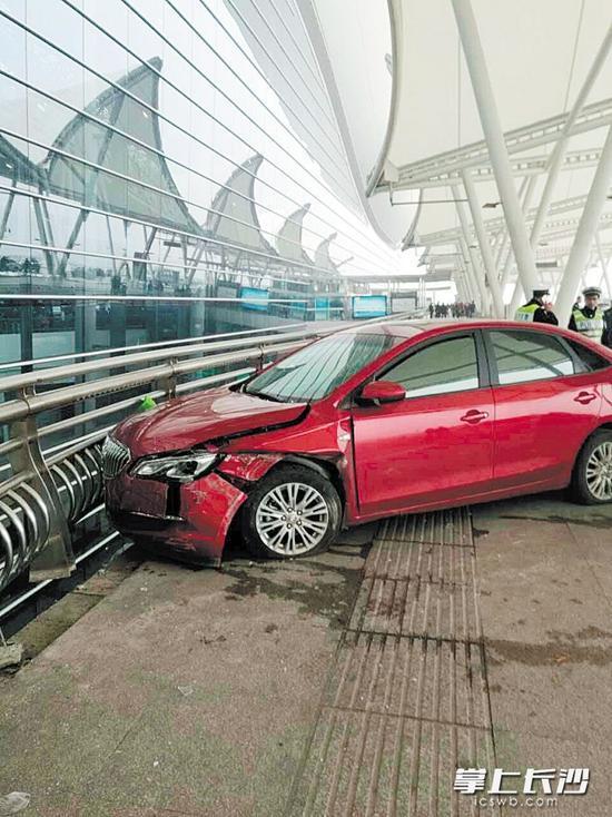 事发现场,这辆红色轿车撞到行人后,撞上护栏才停下来。网友供图