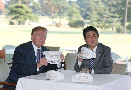 特朗普和安倍晋三在印有“Make alliance even greater”(译为“让美日同盟更伟大”)字样的帽子上签名。