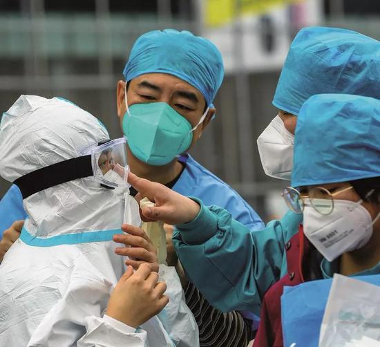 2020年2月12日,武汉江岸塔子湖方舱医院医护人员做好防护工作准备进舱。图/中新