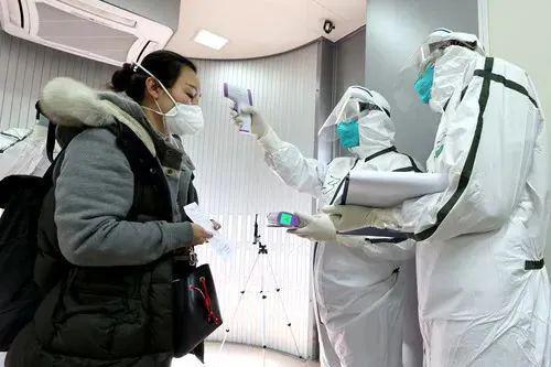 3月7日,工作人员在北京首都国际机场对出入境旅客测量体温。