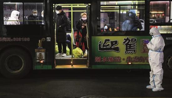 2020年2月5日晚9时,首批新冠病毒肺炎轻症患者陆续抵达武汉国际会展中心方舱医院。摄影/陈卓