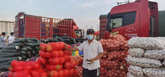 在新发地批发市场临时交易区,经营户正在盘点货品。受访者供图