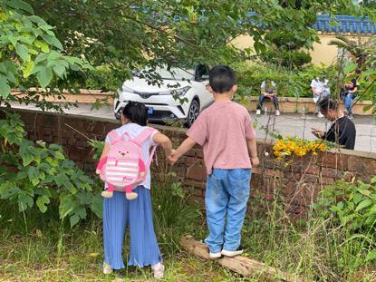 因为花束卖光,一对兄妹在草丛里摘野花准备和妈妈一起去祭奠。健康时报记者张赫摄