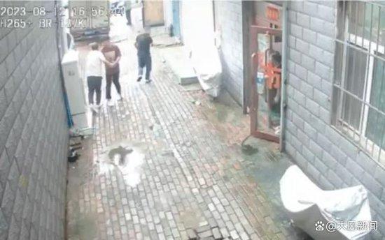 红衣男子一直试图阻挡白衣男子进入库房 监控视频截图