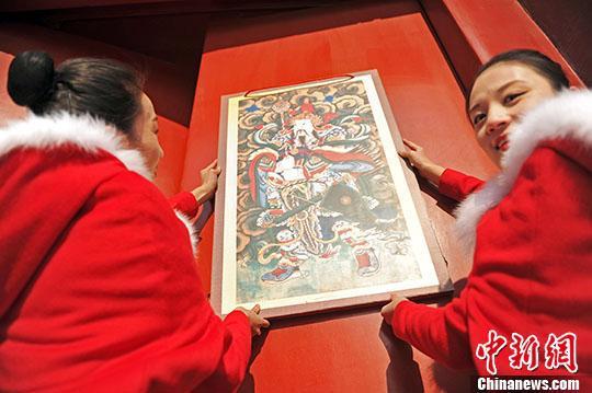 资料图:辽宁沈阳,工作人员于“小年”当天在沈阳故宫内悬挂门神(昊声 摄)